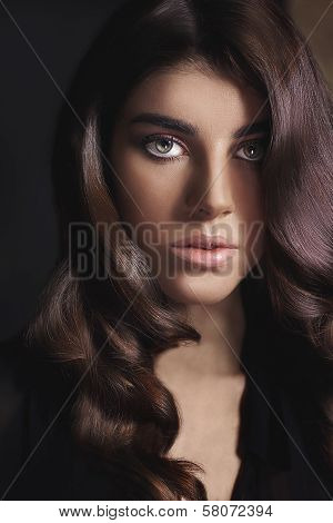 Portrait of young beautiful woman with curly brown hair.