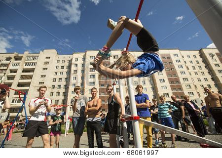 TIKHVIN, RUSSIA - JULY 7, 2014: Unidentified participants city competitions in Street workout timed to the celebration of the day of the city of Tikhvin.