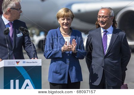 BERLIN, GERMANY - MAY 20, 2014: German Chancellor Angela Merkel (C) and Turkish Minister of transport Lutfi Elvan (R) open up the International aviation and space exhibition ILA.