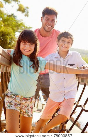 Father With Children On Playground Climbing Frame