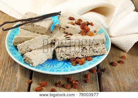 Two kinds of sunflower halva - with raisinas and vanilla taste. on plate, on wooden background