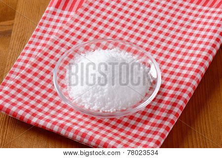 overhead view of coarse salt in the glass bowl with fabric linen