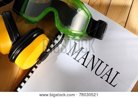 Manual With Goggles And Earphones On Wooden Background