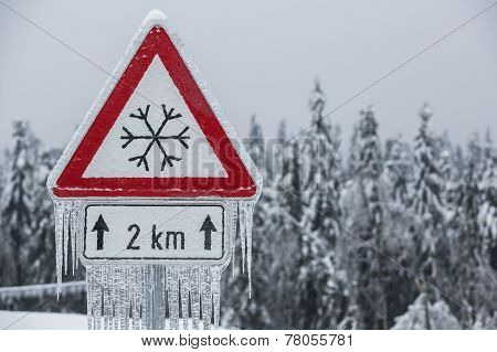 Traffic Sign For Icy Road With Sleet Covered Trees