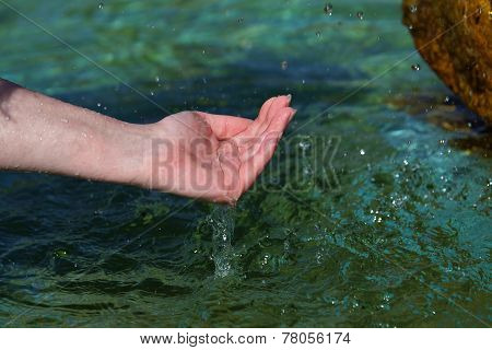 Beautiful woman hand in clear mountain water