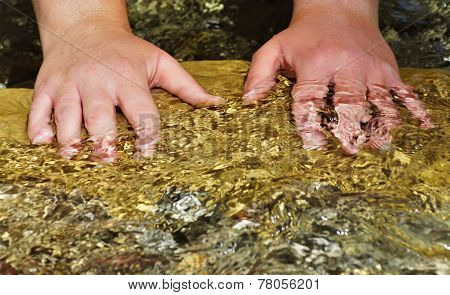 Beautiful woman hand in clear mountain water