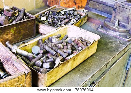 Boxes With Old Bolts On Workbench In Turnery