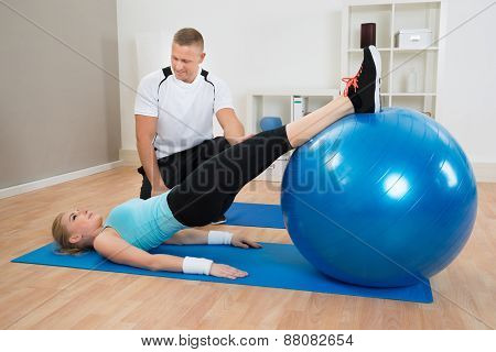 Instructor Looking At Woman Exerting