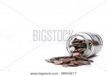 British one penny coins flowing from a glass jar