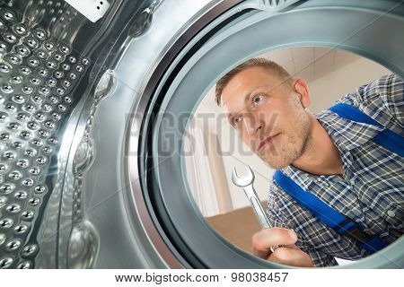 Repairman Looking Inside The Washing Machine