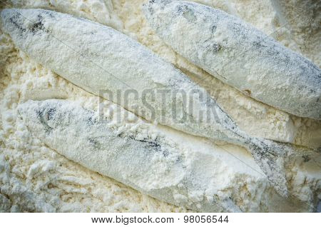 Floury fish on a wooden background. Close up