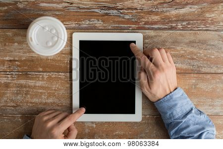 business, education, people and technology concept - close up of male hands with tablet pc computer and coffee paper cup on table