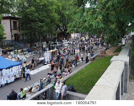 KIEV - UKRAINE - MAY, 2017: Fair on Vladimirskaya street on the Day of Kiev. People walk around the tents with Ukrainian souvenirs. Street lined with paving stones, chestnuts - a symbol of Kiev