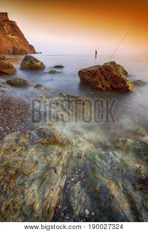 Seascape during sunset. Beautiful natural seascape at long exposure. Stones at foreground