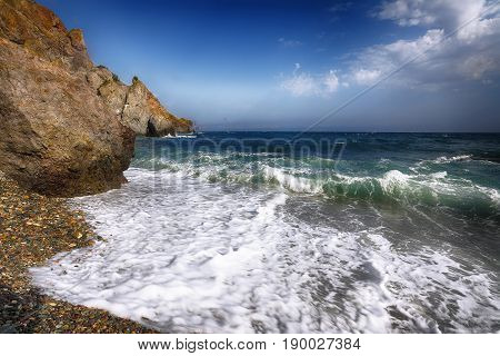Sea waves crashing on the shore and flowing above seashore pebbles. spindrift