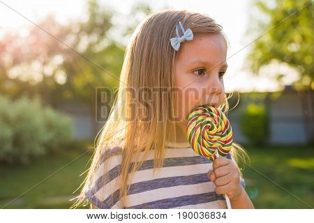 cute cauasian baby girl and big lollipop.