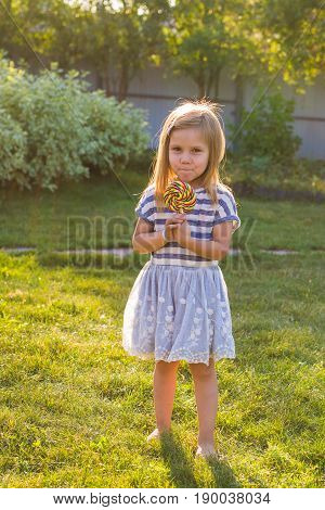 cute cauasian baby girl and big lollipop.