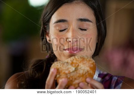Smiling woman smelling a bread at counter in market