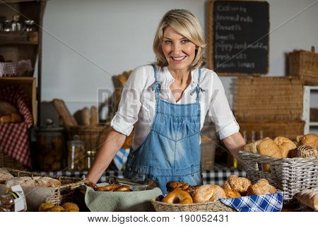 Portrait of female staff standing at bakery section in supermarket
