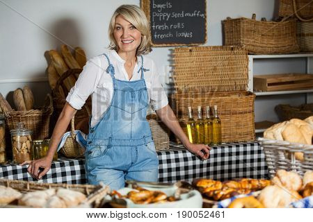 Female staff standing at bakery section in supermarket