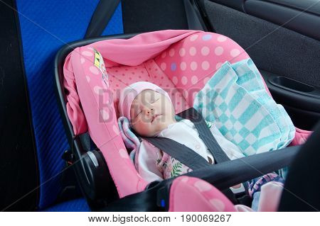 Newborn sleeping in car seat.Safety concept. Infant baby girl. secure driving with children. Baby care lifestyle. Cute baby sleeping in car.