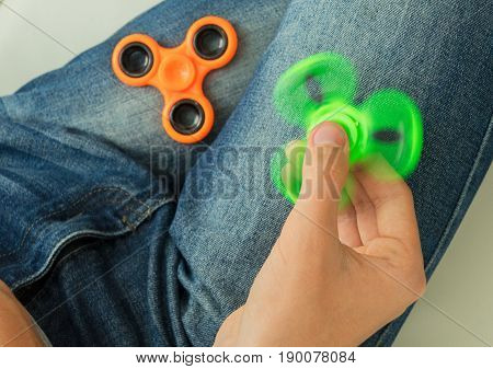 trendy fidget spinner - person holding spinning fidget spinner in hand, close up view