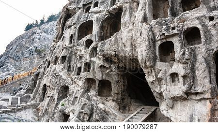 Visitors Near Caves In Slope Of West Hill