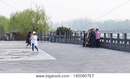 People Take Photo In Longmen Grottoes Area