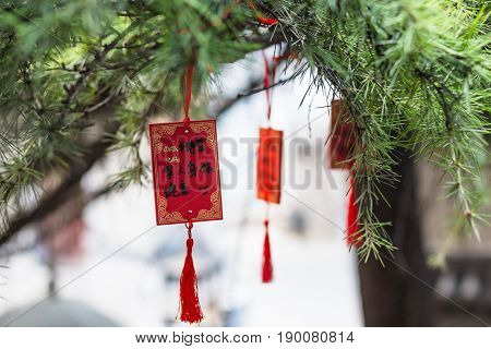 Red Plates On Tree Near Temple
