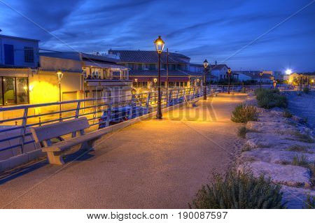 Promenade near mediterranean sea by night, Saintes-Maries-de-la-mer, Camargue, France, HDR