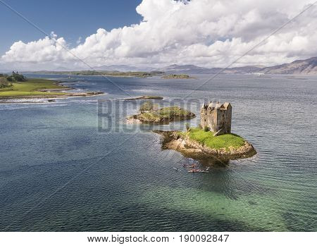 Aerial canoes gathering around the historic castle Stalker in Argyll, Scotland