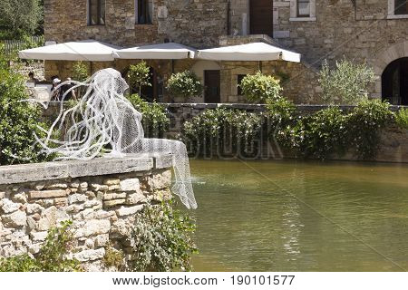 BAGNO VIGNONI, ITALY - JUNE 3 2017: Metal Wires transparent sculpture by Italian sculptress Daniela Capaccioli in Bagno Vignoni medieval town in Tuscany Italy