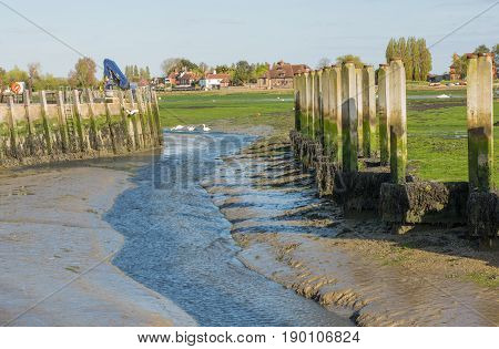 Bosham Quay in Chichester Harbour West Sussex England. Low tide showing mud and seaweed.