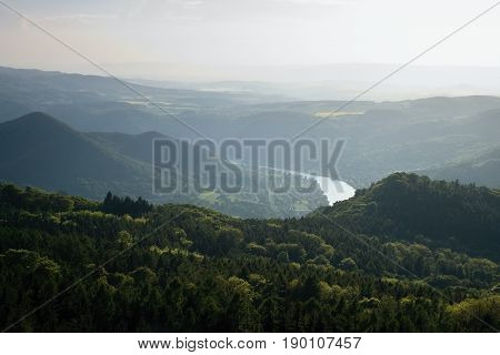 Sunset in valley of european river Labe from metal lookout Varhost in spring evening in czech tourist area named Ceske Stredohori