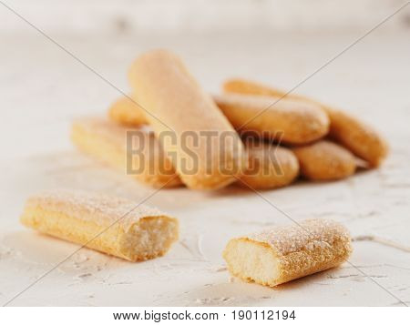 Close up view of ladyfinger biscuit cookie on white concrete background. Italian cookie savoiardi.