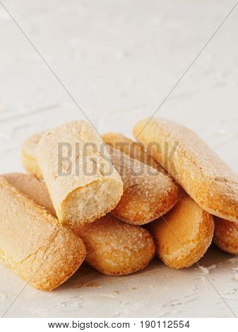 Close up view of ladyfinger biscuit cookie on white concrete background. Italian cookie savoiardi.