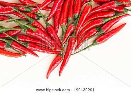 red hot chili peppers, popular spices concept - beautiful handful of red hot pepper in bulk, pods scattered on white background, top view, flat lay, free space for your text