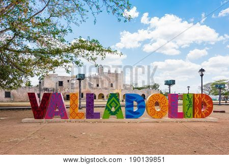 Valladolid, Mexico - April 3, 2017: Colorful letters form the sign of Valladolid with a backdrop of Convent of San Bernardino de Siena on a sunny day in Valladolid, Yucatan, Mexico
