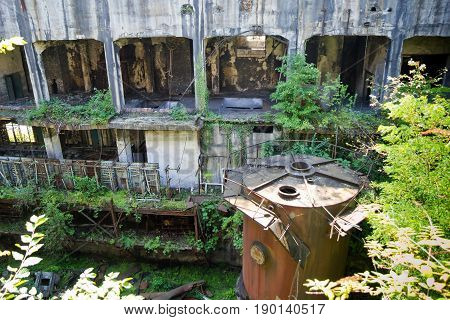 Abandoned overgrown ruins of destroyed by war Tkvarcheli (Tquarhcal) power plant, Abkhazia, Georgia