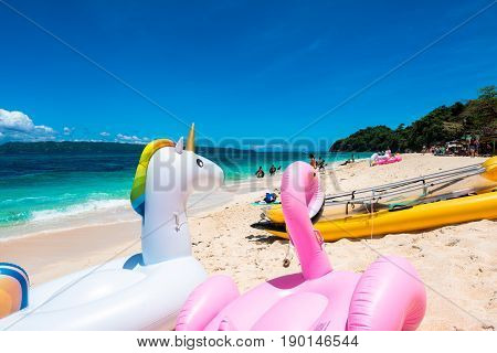 BORACAY, WESTERN VISAYAS, PHILIPPINES - MARCH 25, 2017:  swimming floats of unicorn and flamingo kayak and swimming at the Puka Beach Philippines.