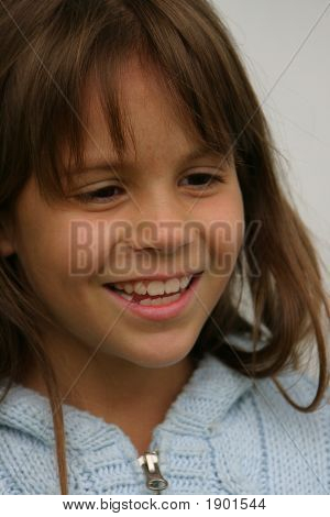 สาวสวยในเสื้อกันหนาวสีฟ้ายิ้มปิดค่า