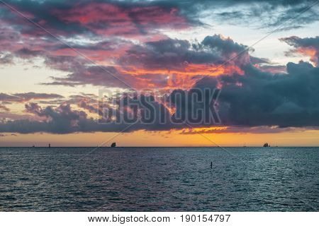 Spectacular sunset over Gulf of Mexico turquoise water viewed from the southernmost point in Key West, Florida.