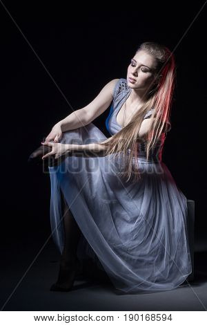 Actress In A Grey Dress On A Dark Stage
