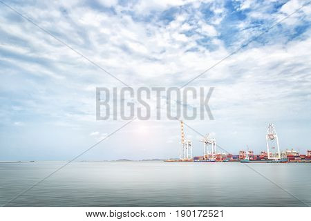 Logistics import export background of Container Cargo ship crane in seaport on blue sky Freight Transportation