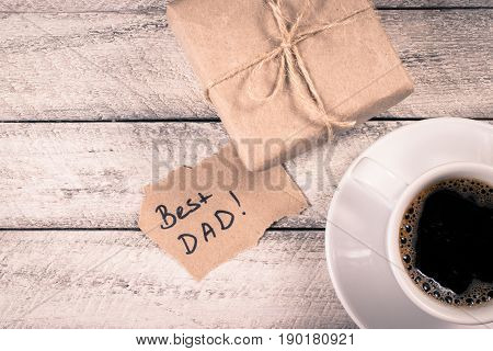 Father's day holiday.  greeting card. coffee and present gift box on wooden background
