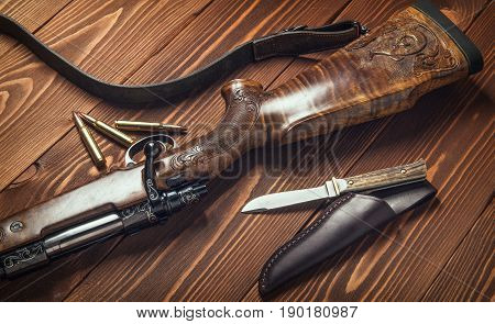 Hunting equipment on old wooden background and bullets.