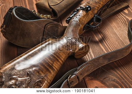 Hunting equipment on old wooden background and bullets.