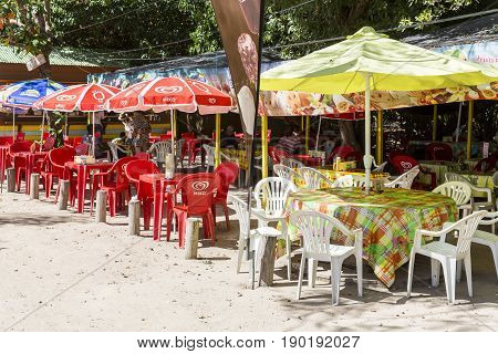 Les Saline Martinique - April 8 2017. Bar closed to the beach on the sand. Plastic chairs and table colored waiting for customers.