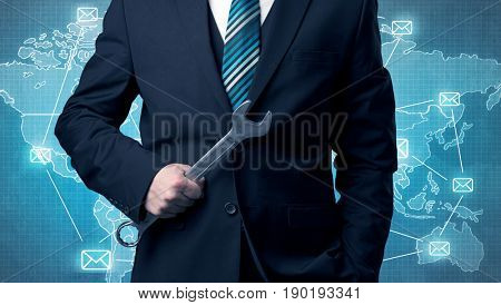 Businessman holding tool with global map graphic on the background