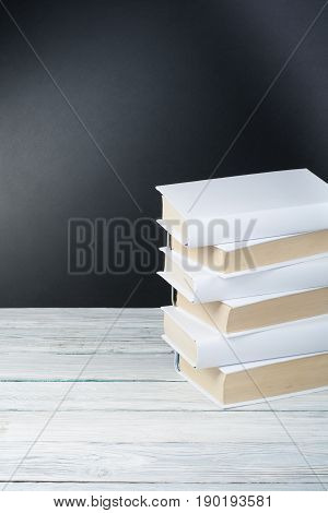 Open black and Whitel books on wooden table, black board background. Back to school. Education business concept